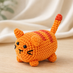 Orangefarbene gehäkelte Katze mit gestreiftem Rücken und aufrechtem Schwanz in Premium-Produktfotografie